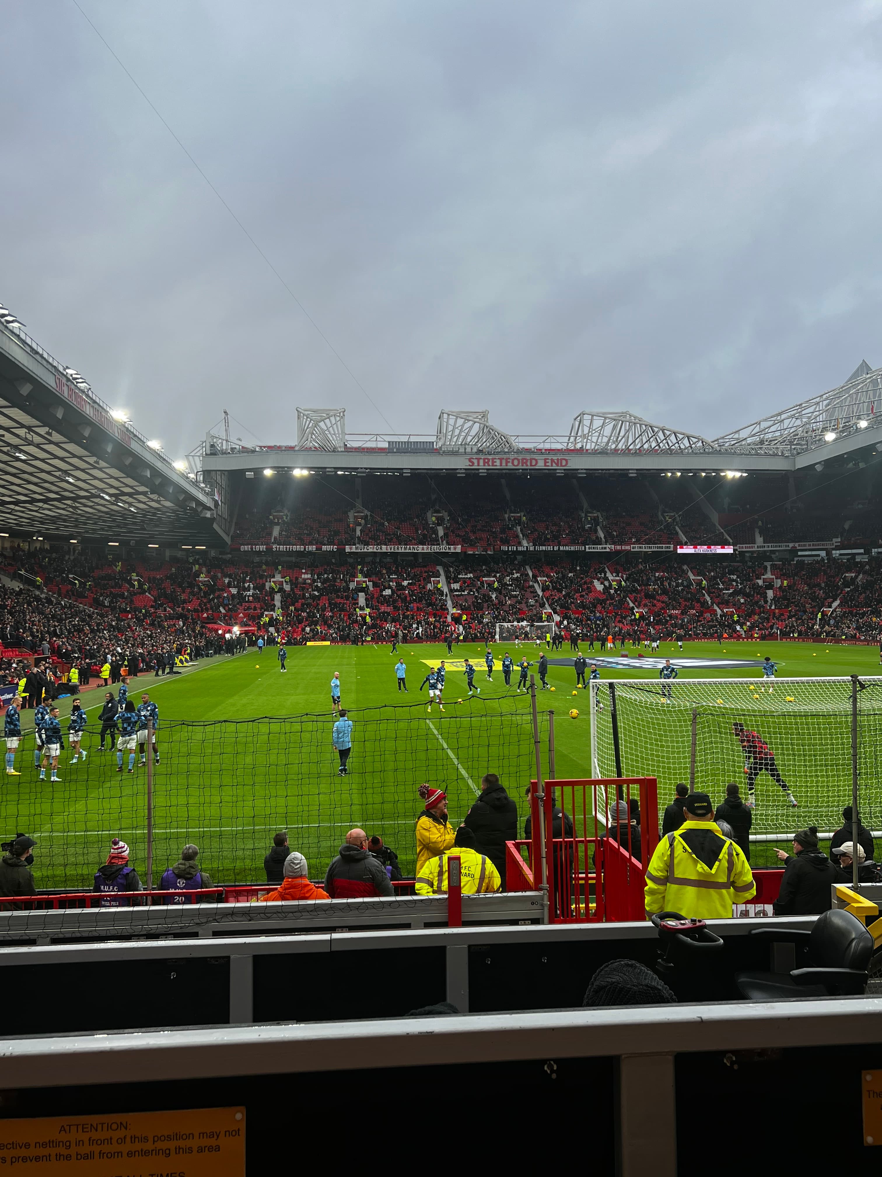 Old Trafford East Stand view Manchester City players warming up Manchester United derby pitch level Premier League matchday