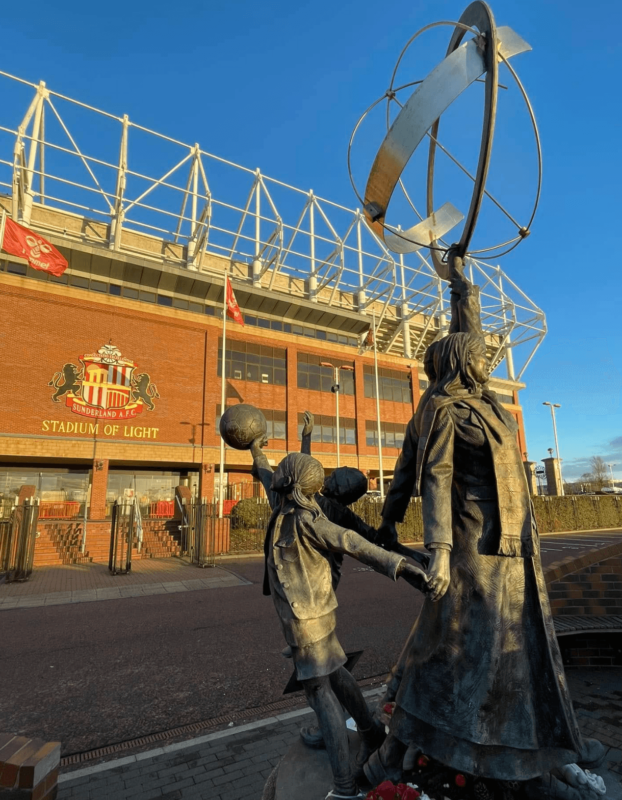 Bronze statue of a man with arms raised outside the Stadium of Light.